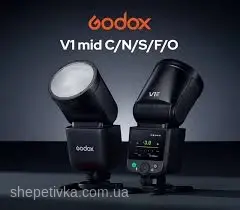 Два спалахи Godox V1 стоять на темному тлі, лівий нахилений вперед демонструючи матову лінзу, правий повернутий задньою панеллю з підсвіченим зеленим екраном управління.